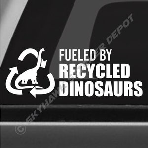 May include: White vinyl sticker with a recycling symbol and a dinosaur inside. The text "Fueled by Recycled Dinosaurs" is below the symbol.