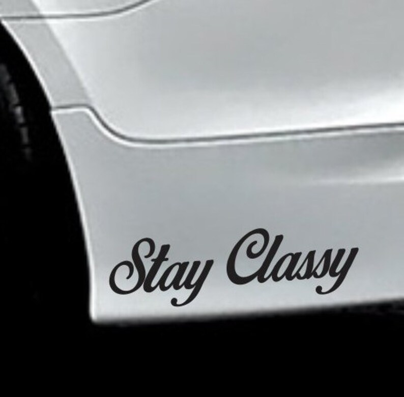 May include: A black and white car with the words "Stay Classy" written on the rear bumper.
