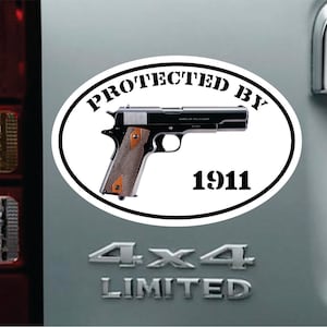 以下が含まれることがあります： 白地に黒文字で「1911で保護」と書かれた楕円形のステッカー。楕円形の中に黒い拳銃が描かれている。ステッカーはグレーの表面に貼られており、その下に「4x4 Limited」という文字が書かれている。