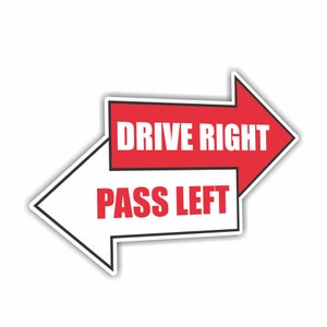 Può includere: Un cartello a forma di freccia bianca e rossa con le scritte "DRIVE RIGHT" e "PASS LEFT". Il cartello ha un bordo nero e uno sfondo bianco. La freccia che punta a destra è rossa e quella a sinistra è bianca.