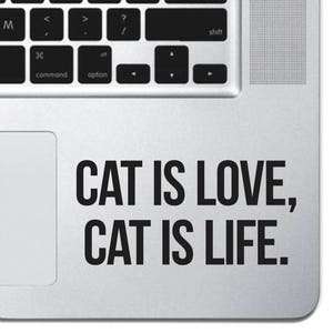 Könnte beinhalten: Ein silberner Laptop mit einem schwarzen Trackpad und einem schwarzen Aufkleber mit der Aufschrift "CAT IS LOVE, CAT IS LIFE."