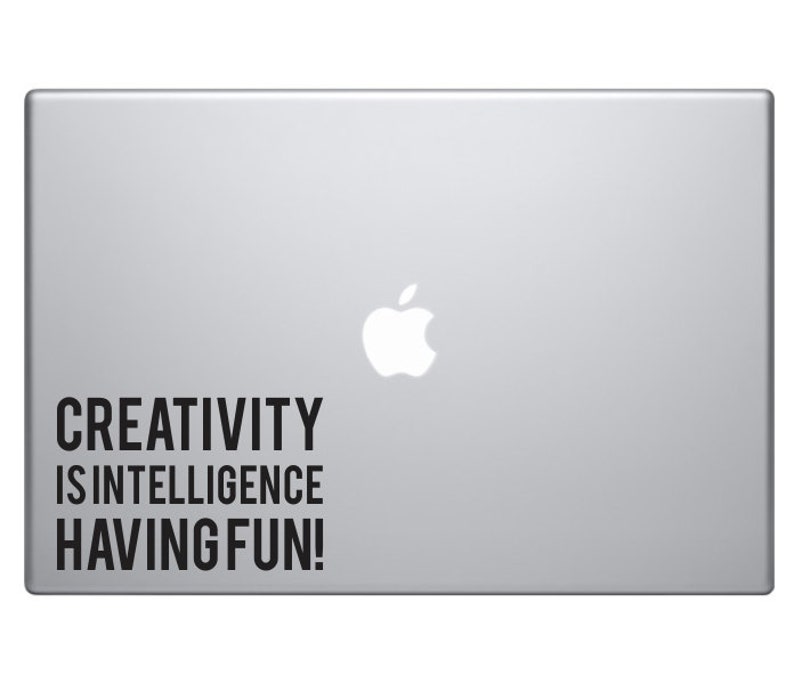 May include: A silver laptop with a white Apple logo and a black sticker that reads "CREATIVITY IS INTELLIGENCE HAVING FUN!"