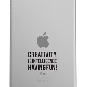 May include: A silver iPad with a black Apple logo and the text "CREATIVITY IS INTELLIGENCE HAVING FUN!" on the back.