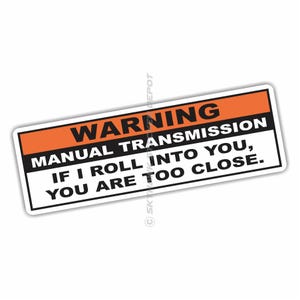 May include: Orange and black warning sticker with the text "WARNING MANUAL TRANSMISSION IF I ROLL INTO YOU, YOU ARE TOO CLOSE."
