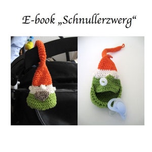 Può includere: Un portaciuccio a forma di gnomo lavorato a uncinetto con uno schema di colori verde, bianco e arancione. Il portaciuccio è attaccato a un passeggino con un anello. Il portaciuccio ha una piccola tasca per un ciuccio.