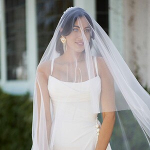 Drop wedding veil with blusher on bride.