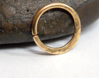 May include: A hammered gold ring with a smooth, rounded finish.