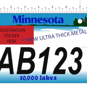 May include: A blue and white Minnesota license plate with the text "10,000 lakes" and the letters "AB123". A red sticker with the text "Registration Sticker Here" is in the upper left corner. The plate is 3 inches wide.