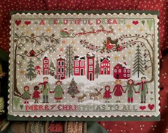 May include: Cross-stitch artwork with a winter holiday theme. The design features a snowy village with red houses, people holding hands, and the text "A Beautiful Dream" and "Merry Christmas to All". A decorative piece.
