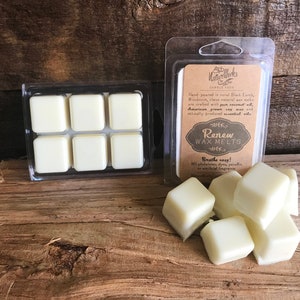 May include: Six white wax melts in a clear plastic container. The container is labeled "Renew Wax Melts" with the text "Breathe easy! NO phthalates, dyes, paraffin or artificial fragrance."
