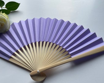 May include: A lavender paper fan with a wooden handle. The fan is folded and closed.