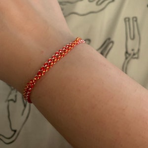 Model kid showing on wrist handmade and handwoven gold-filled and sterling silver kabbalah red cord bracelets for good luck and prosperity made to order and hand-crafted in USA by Lucky Charms USA