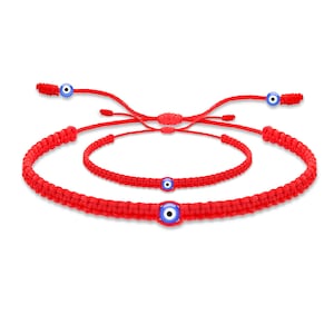 May include: Three red string bracelets with blue evil eye charms. The bracelets are knotted and have adjustable closures.