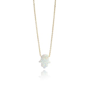 May include: A gold chain necklace with a white opal hamsa hand pendant.