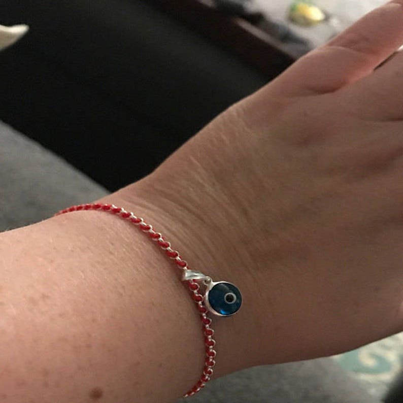 Model girl showing on wrist handmade and hand-woven sterling silver kabbalah red string protection bracelets with blue evil eye charm Handmade-kabbalah-redline-protection-bracelets-gifts by Lucky Charms USA