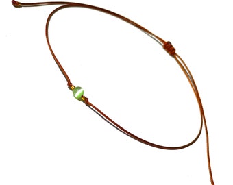 Green selenite choker necklace on brown string with decorative gold-filled beads