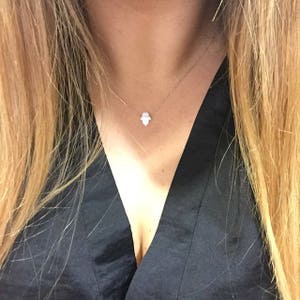 model girl showing white hamsa hand of Fatima in gold-filled chain opal-hamsa-gift by Lucky Charms USA
