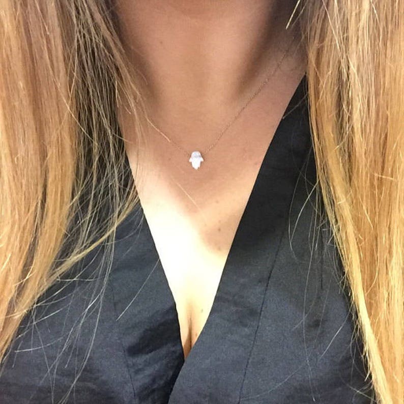 model girl showing white hamsa hand of Fatima in gold-filled chain opal-hamsa-gift by Lucky Charms USA