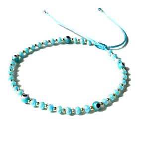 evil eye with blue crystals and gold-filled beads on blue turquoise color string adjustable waterproof handmade gift jewelry for women by Lucky Charms USA