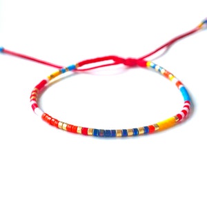 miyuki seed bead Delica bracelet in red, yellow, black, gold, white, light blue, color beads, on adjustable red string waterproof bracelet handmade to order in USA by Lucky Charms USA