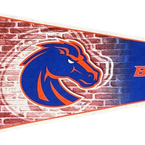 May include: A pennant featuring the Boise State Broncos logo. The pennant has a blue background with the word "BOISE" in orange. The logo is a blue horse head with orange accents, set against a brick wall design.
