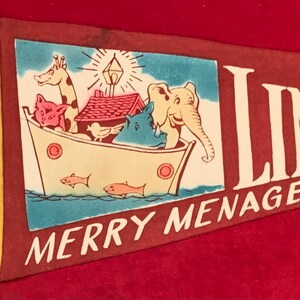 May include: A red felt pennant with a white border and the words "Merry Menagerie" and "Linc" in white. The pennant features a colorful illustration of a boat with animals, including a giraffe, pig, bird, rhino, and elephant.