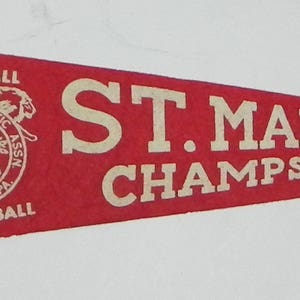 May include: Red felt pennant with white lettering that reads "St. Marco Champs". The pennant has a white circle with a logo that reads "St. Marco Athletic Assoc. Temple, Pa. Softball Basketball".
