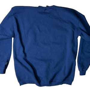 May include: A navy blue sweatshirt with a crew neck and long sleeves.