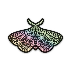 May include: A black and white sticker of a moth with intricate floral and moon designs. The sticker has a holographic finish that shifts colours from pink to green.