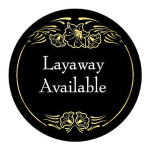 Puede incluir: Un letrero circular negro y dorado con un borde floral decorativo. El letrero dice "Layaway Available" en texto blanco.