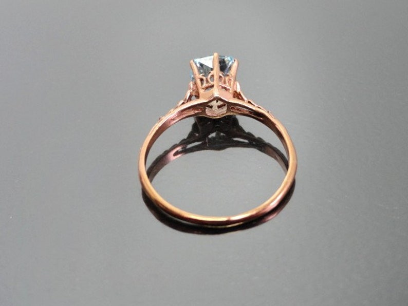K&ouml;nnte beinhalten: Ein Verlobungsring aus Ros&eacute;gold mit einem filigranen Design und einem klaren Stein in der Mitte.