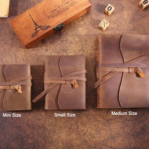 May include: Three brown leather journals of different sizes, labeled "Mini Size", "Small Size", and "Medium Size". Each journal has a leather strap closure and is made of distressed leather.
