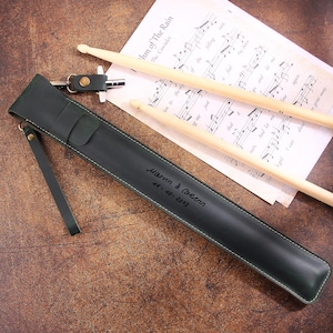 Peut inclure: Un &eacute;tui &agrave; baguettes en cuir vert fonc&eacute; avec une sangle et une inscription personnalis&eacute;e qui dit "Harm & Carmen 14-10-2013".