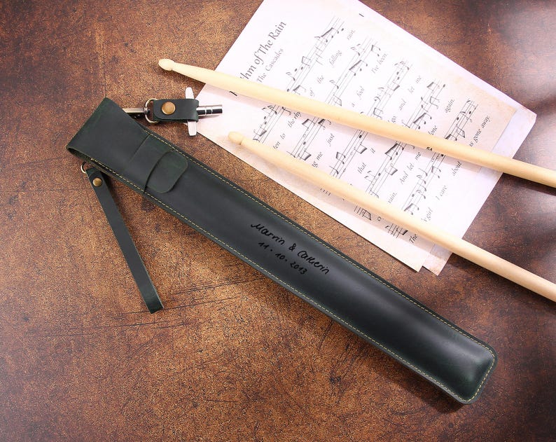 Peut inclure: Un &eacute;tui &agrave; baguettes en cuir vert fonc&eacute; avec une sangle et une inscription personnalis&eacute;e qui dit "Harm & Carmen 14-10-2013".