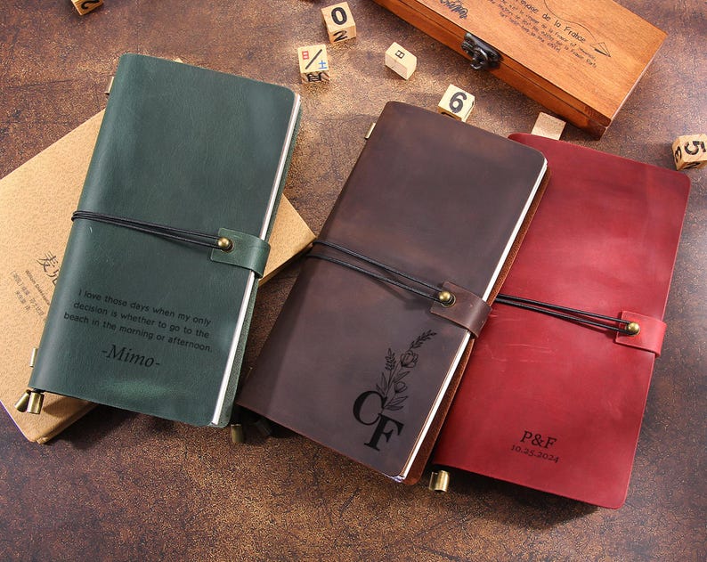 May include: Three leather journals in green, brown, and red. The green journal has the text "I love those days when my only decision is whether to go to the beach in the morning or afternoon -Mimo-". The brown journal has the initials "CF" and a floral design. The red journal has the initials "P&F" and the date "11.25.2024".