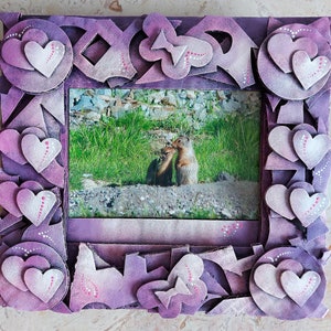Cadre photo mural coeurs pour photographies 4 x 6. Fait de carton ondulé recyclé et de matériaux robustes.