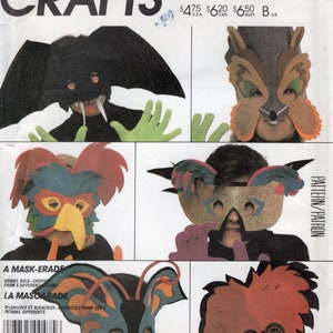 May include: A vintage McCall's Crafts pattern envelope featuring six different mask designs. The masks include a bat, owl, bird, and butterfly, with the text "A Mask-erade" and "La Mascarade" visible.