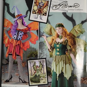 May include: A Simplicity Costumes sewing pattern envelope S0790 featuring two costume designs. One shows a purple hat, star-print bodice, orange skirt, and striped stockings. The other shows a green dress with leaf-like wings and a headpiece.