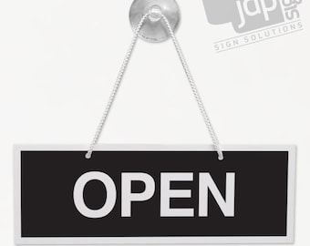 May include: Black and white hanging sign with the word "OPEN" in white letters on a black background. The sign is attached to a clear suction cup and string.