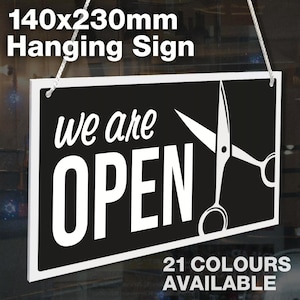 May include: Black and white hanging sign with the text "we are OPEN" and a pair of scissors. The sign is 140mm x 230mm and is available in 21 colors.