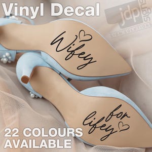 May include: Pale blue high heels with the words "Wifey" and "Lifey for Lifey" in black script on the soles. The heels have a pointed toe and a small heel. The text "Vinyl Decal" and "22 Colours Available" are also visible.