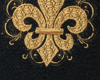 May include: A gold embroidered fleur-de-lis design on a black fabric background.