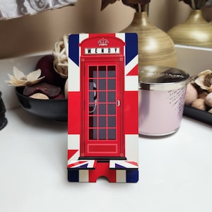 Puede incluir: Soporte de teléfono de cabina telefónica roja con diseño de Union Jack. La cabina telefónica tiene un letrero que dice "WENDY".