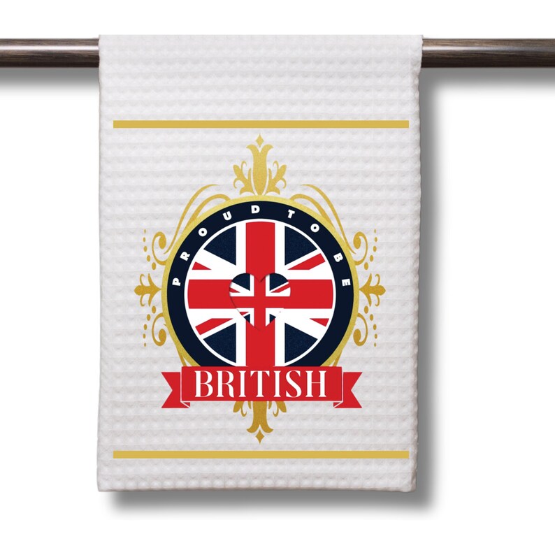May include: White kitchen towel with a gold and red design. The design features a circle with the Union Jack flag and the words "Proud to be British".
