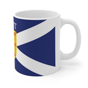 May include: White ceramic mug with a blue and white Scottish flag design. The flag features a white diagonal cross on a blue background with a yellow and red crest in the upper left corner. The text "SCOTT" is printed on the mug.