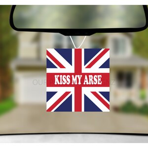 May include: A car air freshener with a Union Jack design and the text "KISS MY ARSE" in white letters.