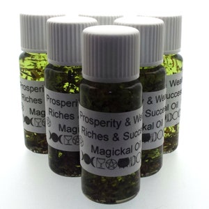 Può includere: Sei piccole bottiglie di vetro con tappi bianchi riempite di un liquido verde e erbe. Le bottiglie hanno etichette bianche con testo nero che recita "Prosperity & Wealth Riches & Success Magickal Oil".