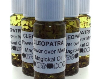 May include: Six small glass bottles filled with a yellow liquid and herbs. Each bottle has a white label with black text that reads "CLEOPATRA Power over Men Magickal Oil".