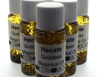 May include: Six small glass bottles with white lids filled with a clear liquid and herbs. The bottles have white labels with black text that reads "Hecate Goddess Magickal Oil" and symbols.