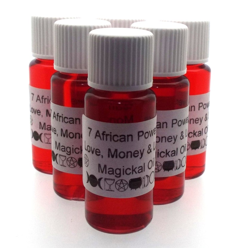 Op de afbeelding: Zes kleine rode glazen flesjes met witte dopjes en etiketten. De etiketten hebben witte tekst die "7 African Power Love, Money & Luck" en "Magickal Oil" zegt.